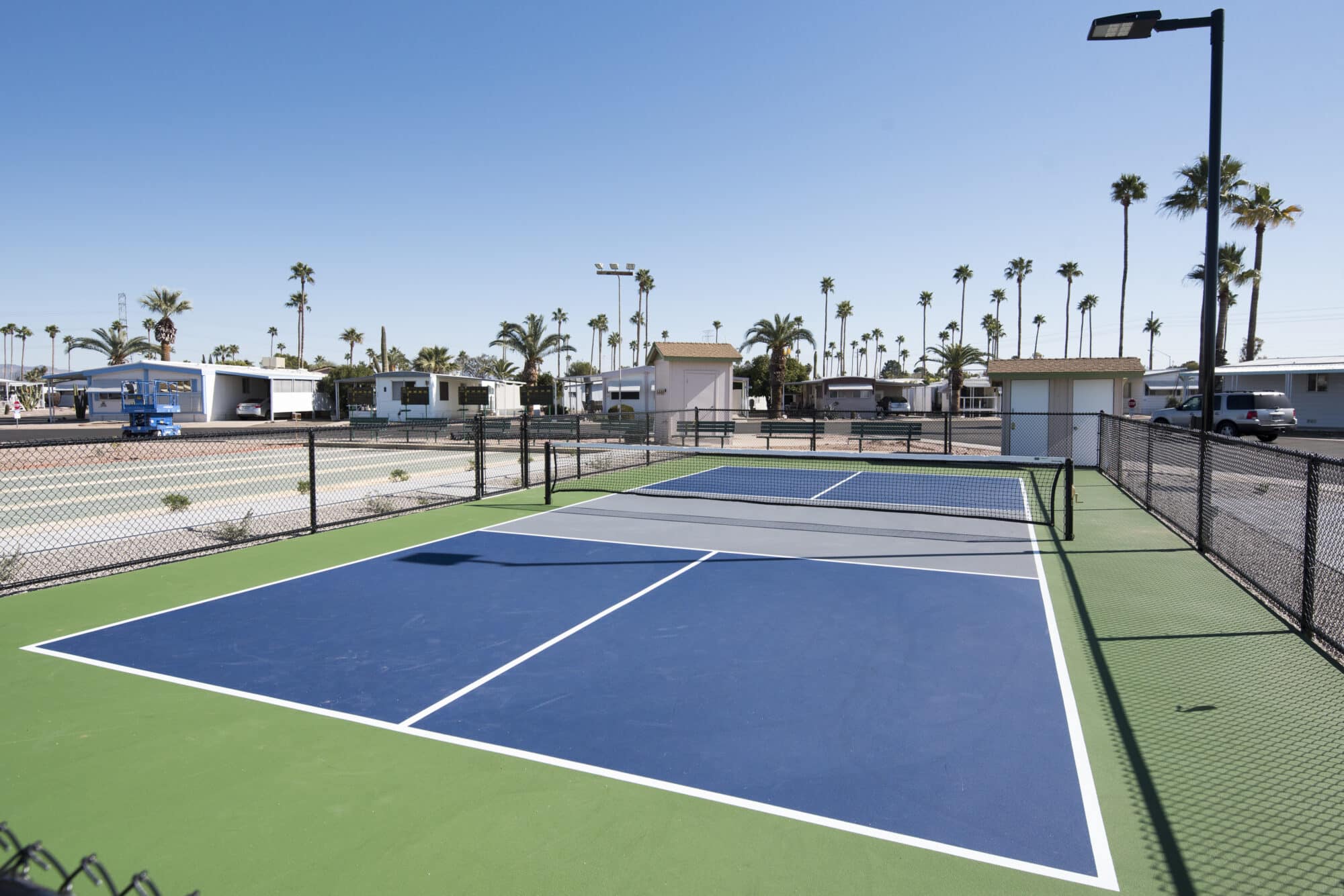 Manufactured homes community tennis court with wired fence in Mesa, Arizona